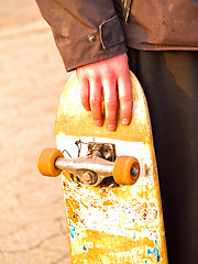 Image showing Grunge image of a skater holding his skateboard