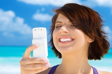 Image showing happy woman with phone on the beach