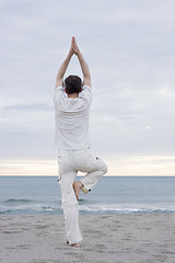 Image showing Man doing yoga on beach