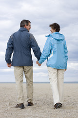 Image showing Mature couple walking on a beach