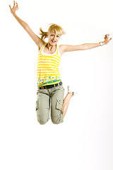 Image showing casual young woman jumps in the air