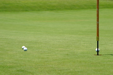 Image showing Golf balls near flagstick