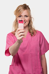 Image showing Female nurse holding up cell phone