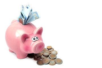 Image showing Piggy bank stuffed with money and surrounded by coins.