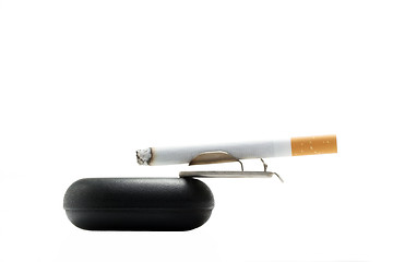 Image showing Cigarette on ashtray over white