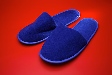 Image showing Blue slippers on red background