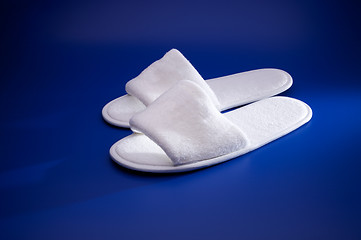 Image showing White slippers on blue background
