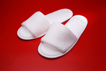 Image showing White slippers on red background
