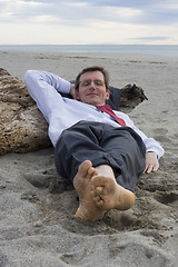 Image showing Businessman sleeping on a beach