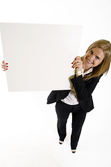 Image showing wide angle picture of an attractive businesswoman presenting a blank board