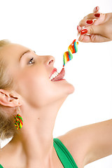 Image showing closeup of an attractive woman liking a lolly pop