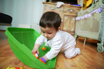 Image showing adorable baby plays on floor, soft focus
