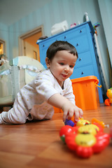 Image showing infant plays on floor, soft focus