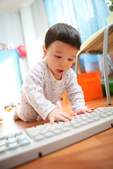 Image showing baby and computer keyboard, soft focus