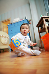 Image showing adorable infant plays in the room, soft focus