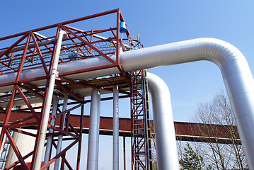 Image showing industrial pipelines on pipe-bridge against blue sky  