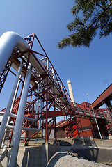 Image showing industrial pipelines on pipe-bridge against blue sky  