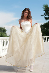 Image showing attractive young woman in white-golden gown