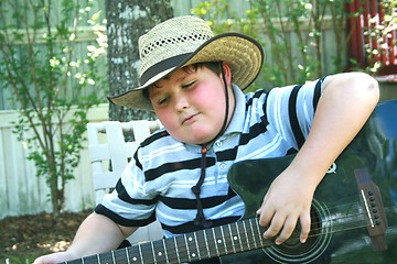 Image showing Young boy playing guitar