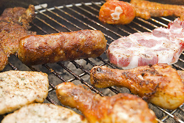 Image showing Sausages, beef and other meat on a barbecue