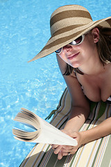 Image showing Woman in Sunhat Reading by Pool