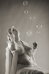 Image showing pregnant woman blows bubbles