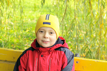 Image showing Smiling boy on bench