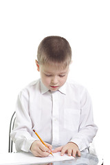 Image showing Boy in white writing at table