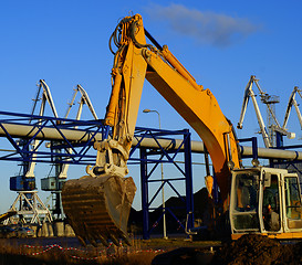 Image showing Hydraulic excavator at work. Shovel bucket against blue sky