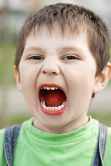 Image showing Shouting boy with orange tongue