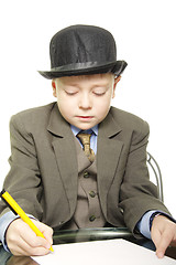 Image showing Boy in hat with pen and paper