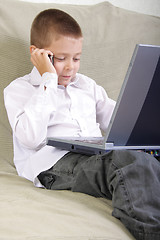 Image showing Boy with laptop talking by phone