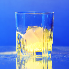 Image showing Whiskey glass with burning ice on dusty table