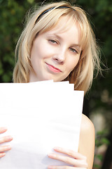 Image showing Fair-haired girl with with blank papers