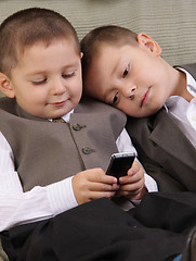 Image showing Brothers looking to phone