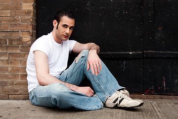 Image showing Man sitting on concrete