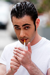 Image showing Man lighting cigarette