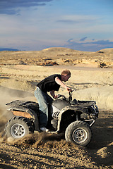 Image showing teen riding quad ATV in the hills