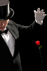 Image showing young magician performing red rose