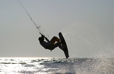 Image showing kiteboarder taking off for a jump