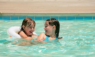 Image showing Sisters Playing in a Pool Outdoors