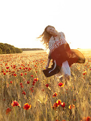Image showing Blonde walking in poppy field