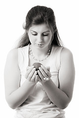 Image showing beautiful girl looks at apple on palms