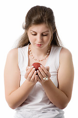Image showing beautiful girl looks at apple on palms