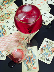 Image showing Broken glass, wine with ice and cards