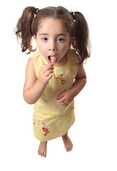 Image showing Little girl eating a lollipop candy