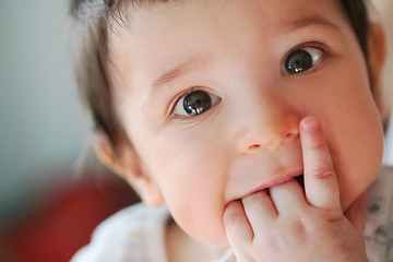 Image showing small boy touches their own first teeth