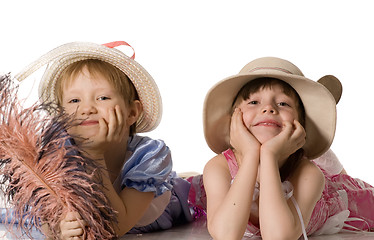 Image showing little girls in hats lie on the floor and smile