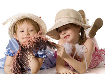 Image showing Little girls in hats lie on  floor