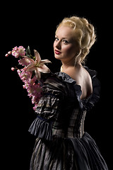 Image showing Beautiful young woman with flowers on black background